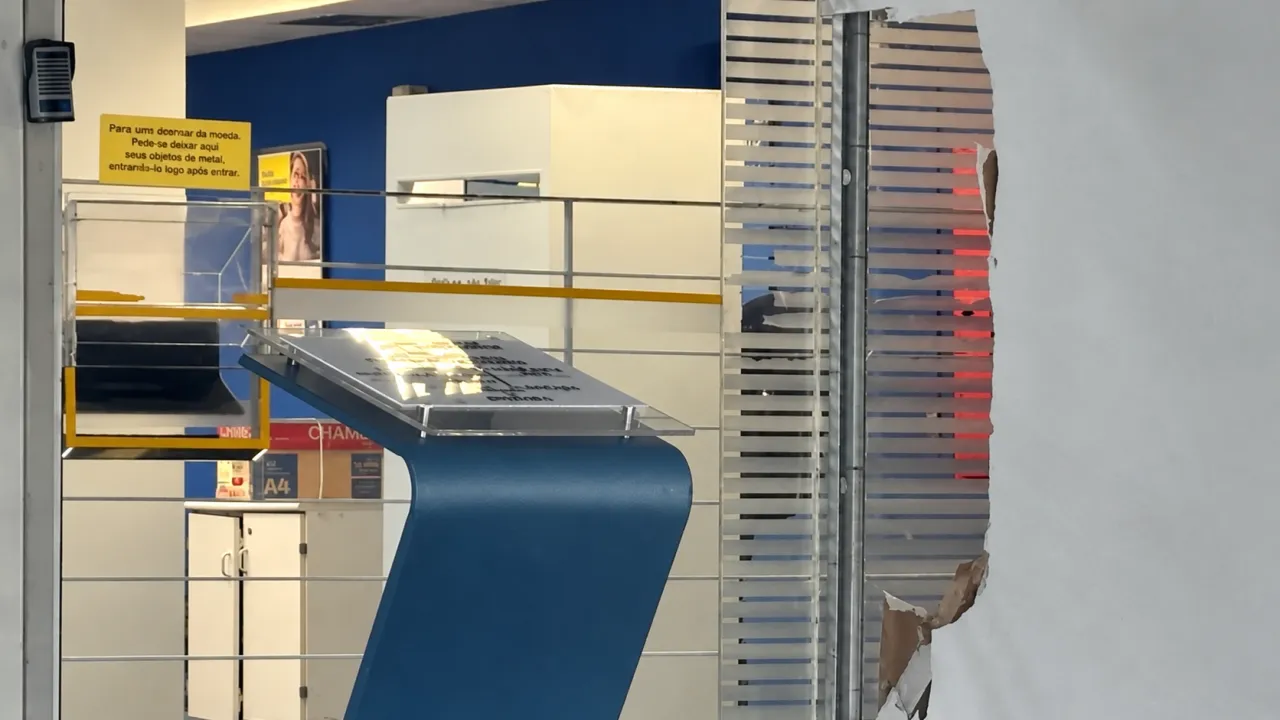 Interior da agência do Banco do Brasil em Porto Alegre, com dano visível na parede próximo à entrada.