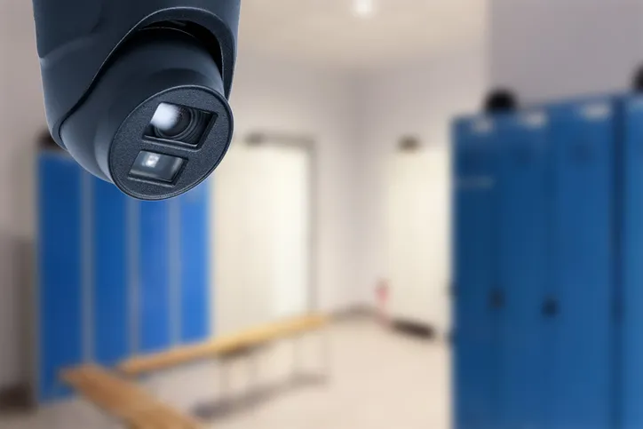 Câmera de segurança instalada em vestiário com armários; imagem ilustrativa sobre privacidade no ambiente de trabalho.
