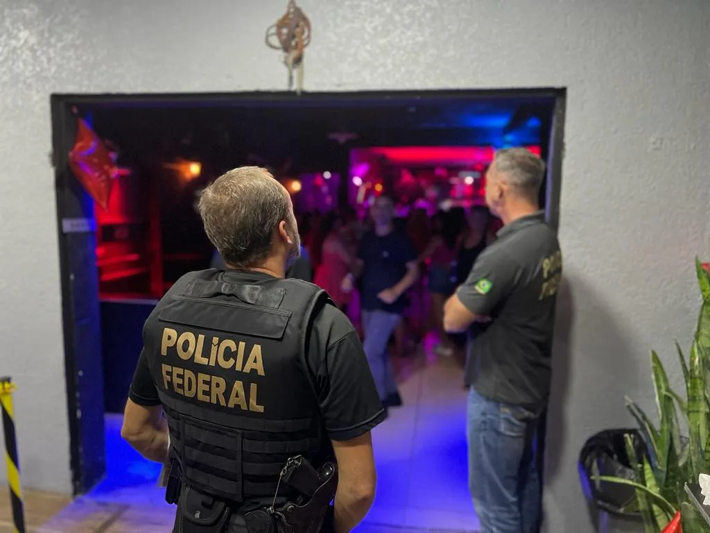 Policiais federais fiscalizam a entrada de uma casa noturna durante operação em Foz do Iguaçu.