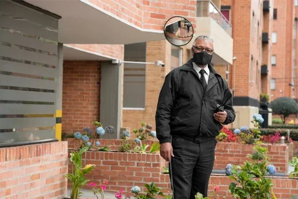 Profissional de segurança na entrada de um condomínio residencial, em imagem ilustrativa sobre fiscalização de rondas.