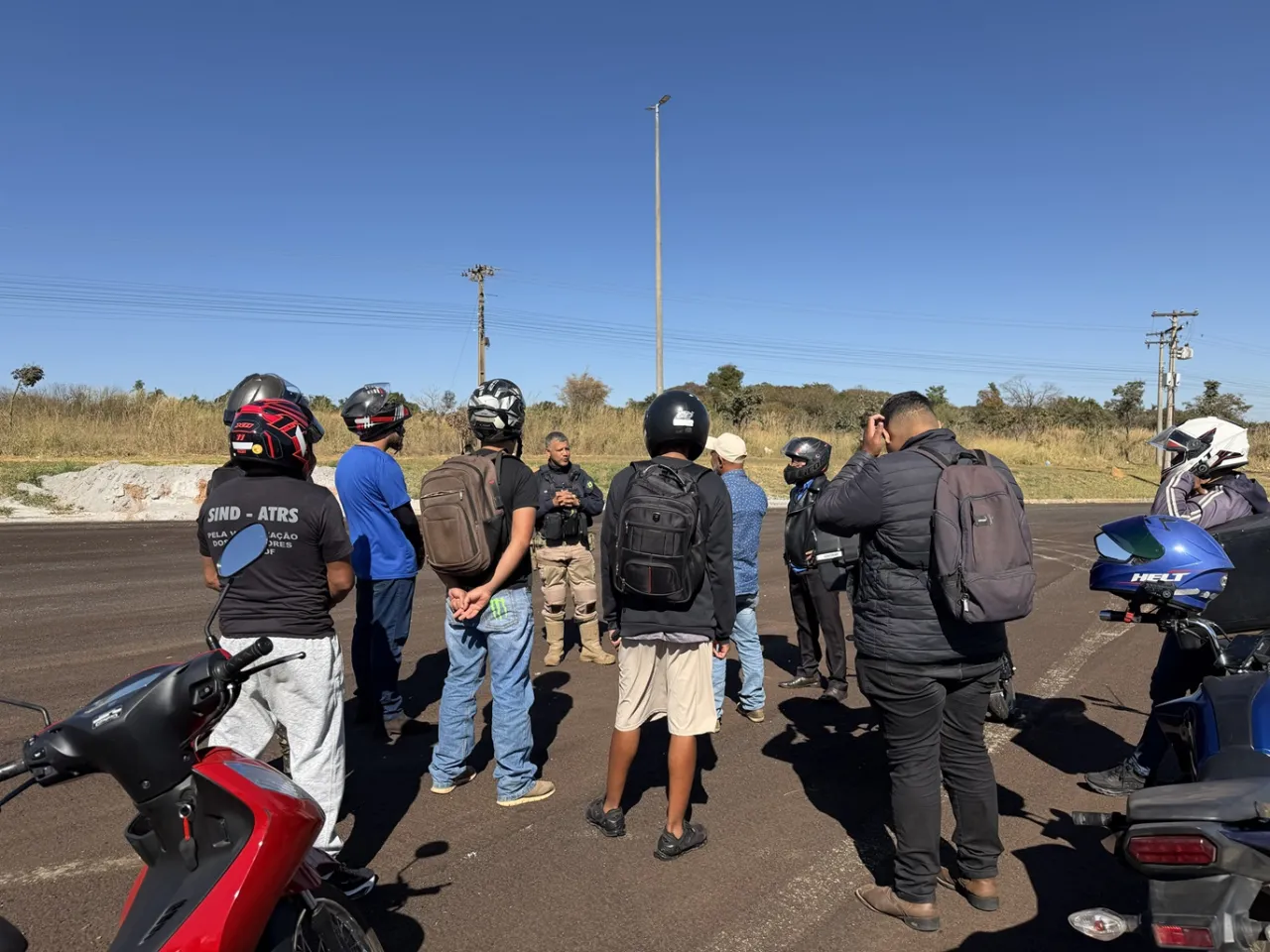 Ação educativa da Polícia Rodoviária Federal com motociclistas em rodovia, ilustrando cuidados no trajeto do vigilante.